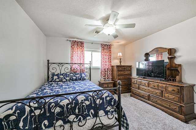 bedroom with ceiling fan, carpet flooring, and a textured ceiling