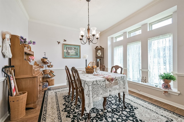 dining space with crown molding, a wealth of natural light, a chandelier, and hardwood / wood-style flooring