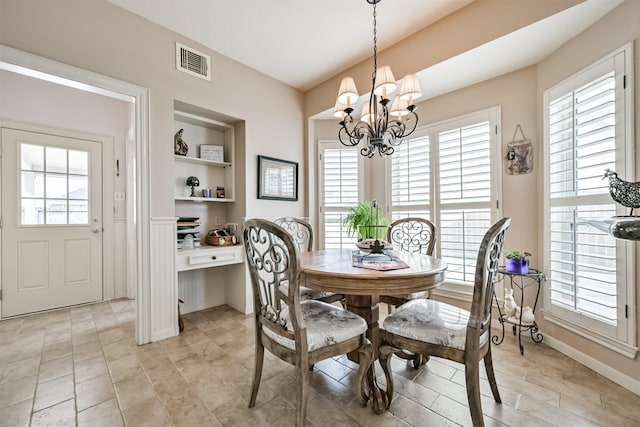 dining area with a healthy amount of sunlight, a notable chandelier, and built in shelves