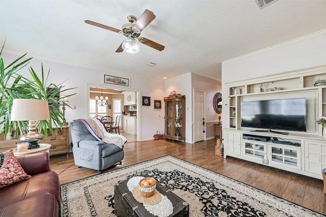 living room featuring crown molding, ceiling fan with notable chandelier, dark hardwood / wood-style floors, and a textured ceiling