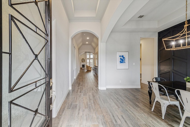 foyer with hardwood / wood-style flooring and a raised ceiling