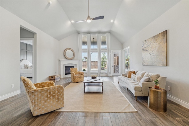 living room with lofted ceiling, wood-type flooring, a premium fireplace, and ceiling fan