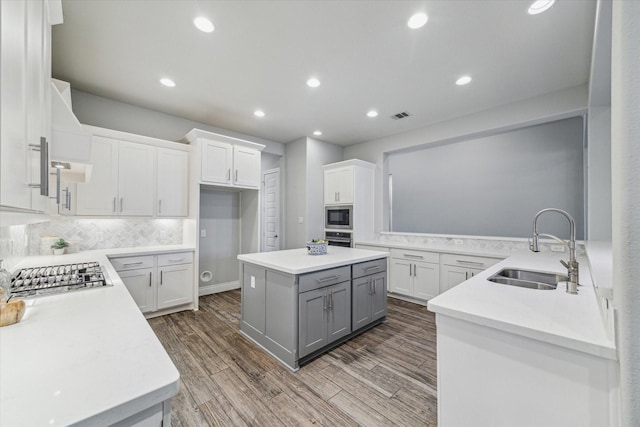 kitchen featuring stainless steel appliances, white cabinetry, sink, and kitchen peninsula