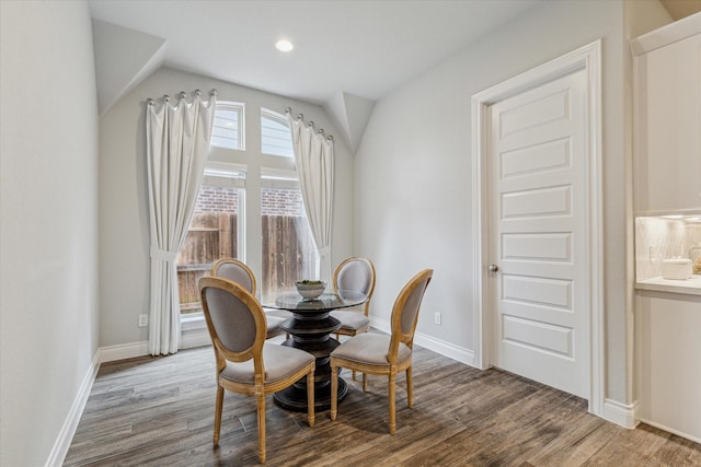 dining space featuring hardwood / wood-style floors and vaulted ceiling