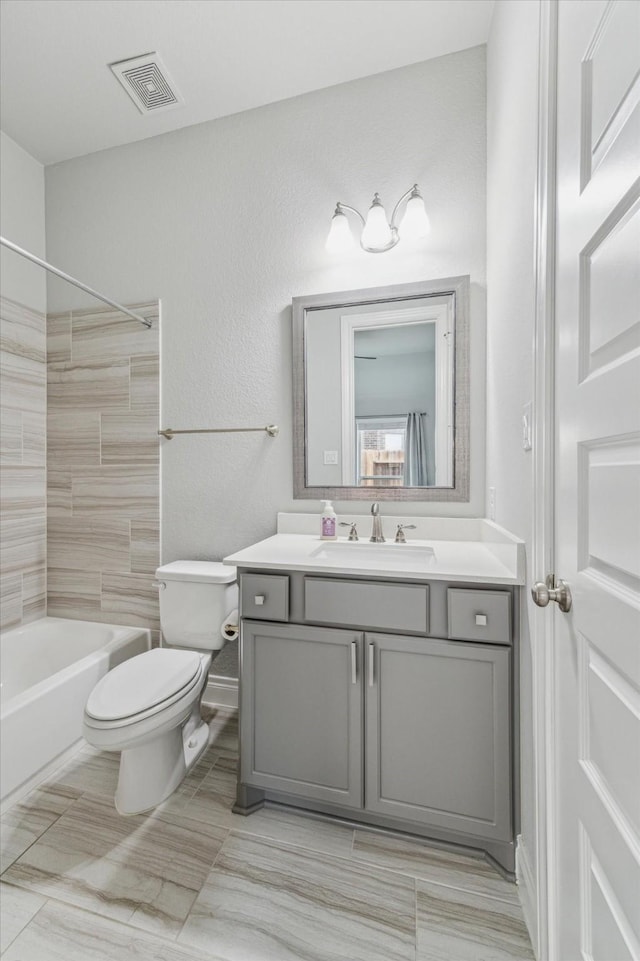 full bathroom with vanity, tiled shower / bath combo, and toilet