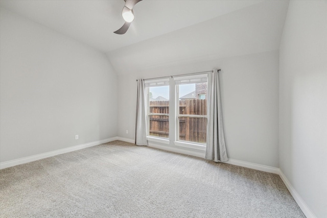 carpeted empty room with ceiling fan and vaulted ceiling