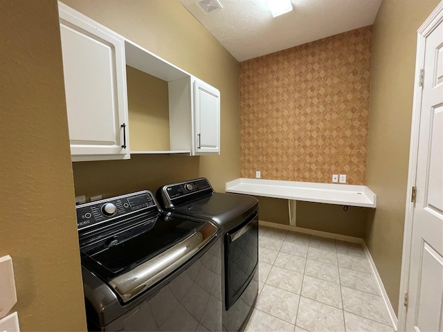 laundry area featuring cabinet space, visible vents, baseboards, independent washer and dryer, and light tile patterned flooring