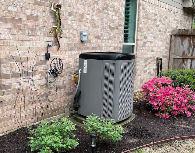 details featuring central AC and brick siding