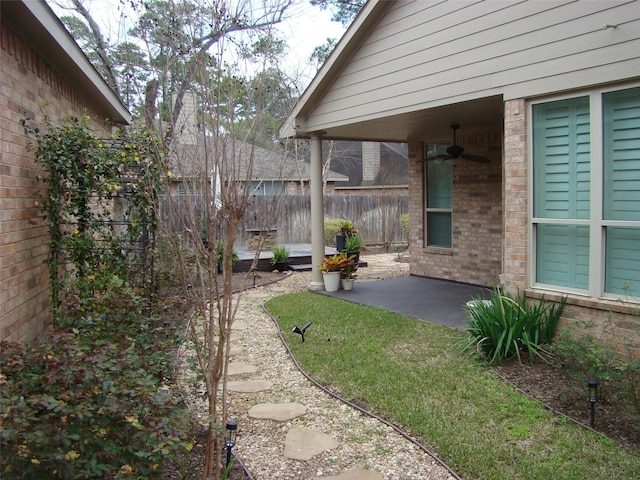 view of yard featuring a patio area, ceiling fan, and fence