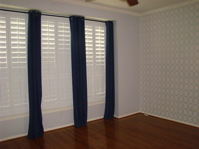 unfurnished room featuring ornamental molding, wood finished floors, and baseboards