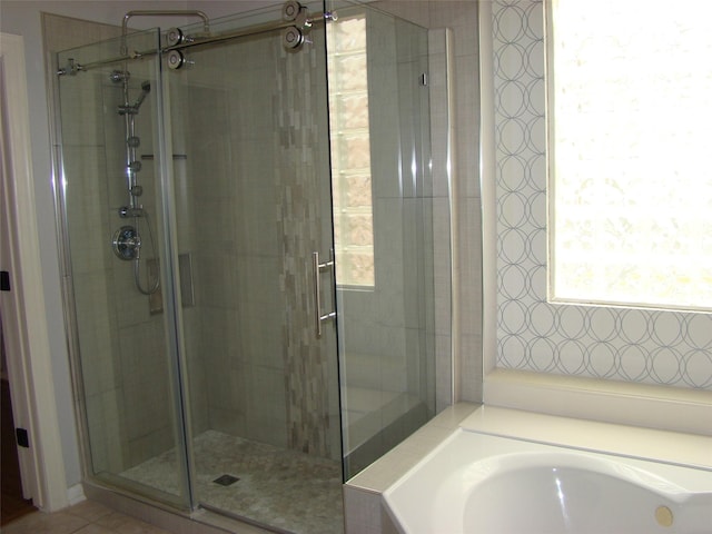 full bathroom featuring a stall shower and a garden tub