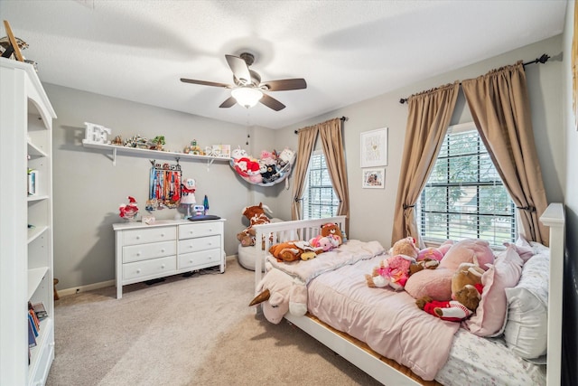 bedroom featuring a ceiling fan, light colored carpet, and baseboards