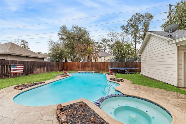 view of swimming pool featuring a lawn, a patio, a fenced backyard, a trampoline, and a pool with connected hot tub