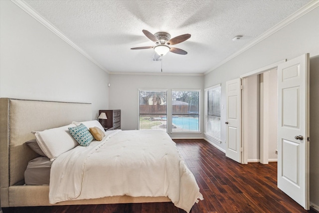 bedroom featuring a textured ceiling, dark wood finished floors, a ceiling fan, and crown molding