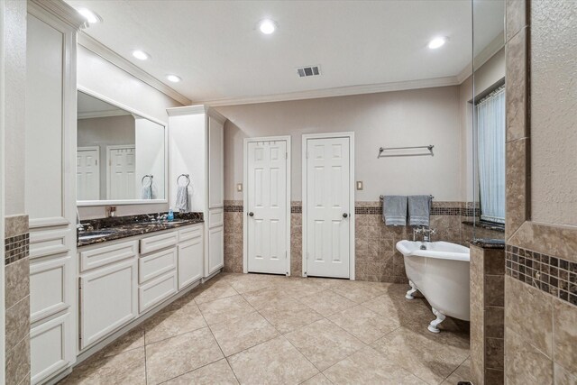 bathroom featuring tile walls, recessed lighting, vanity, tile patterned flooring, and a freestanding tub