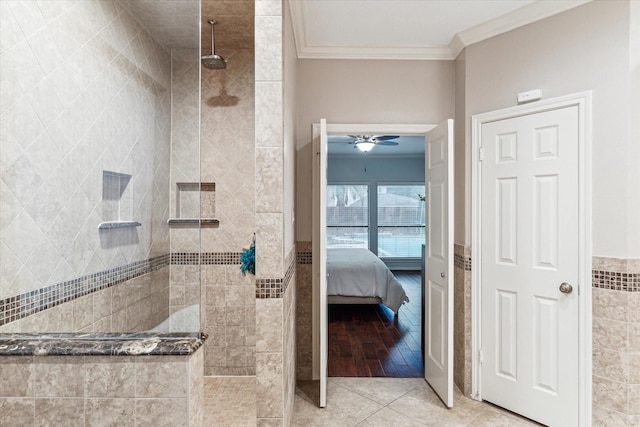 bathroom featuring ornamental molding, ensuite bathroom, tile patterned flooring, a walk in shower, and tile walls