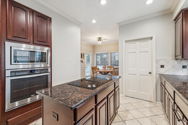 kitchen featuring black electric cooktop, decorative backsplash, stainless steel microwave, dark stone countertops, and crown molding