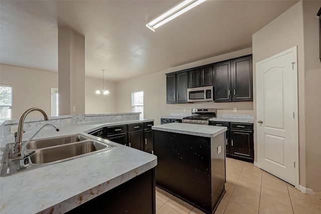 kitchen featuring a kitchen island, pendant lighting, sink, light tile patterned floors, and stainless steel appliances