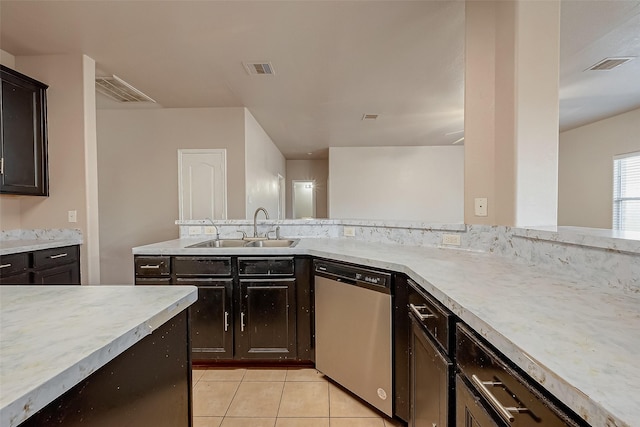 kitchen with dark brown cabinets, sink, stainless steel dishwasher, and light tile patterned floors