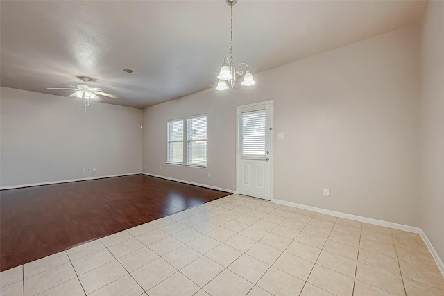 empty room with ceiling fan with notable chandelier and light hardwood / wood-style flooring