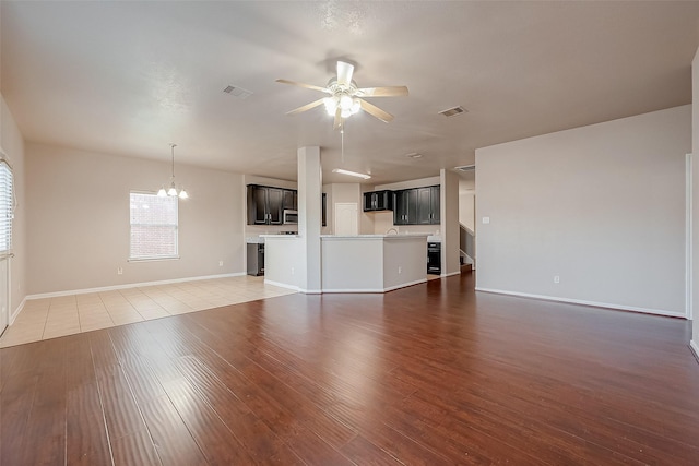 unfurnished living room with wood-type flooring and ceiling fan with notable chandelier