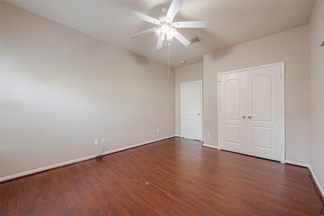 unfurnished bedroom featuring ceiling fan and dark hardwood / wood-style flooring