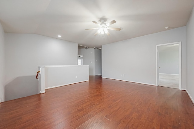 empty room with vaulted ceiling, dark hardwood / wood-style floors, and ceiling fan