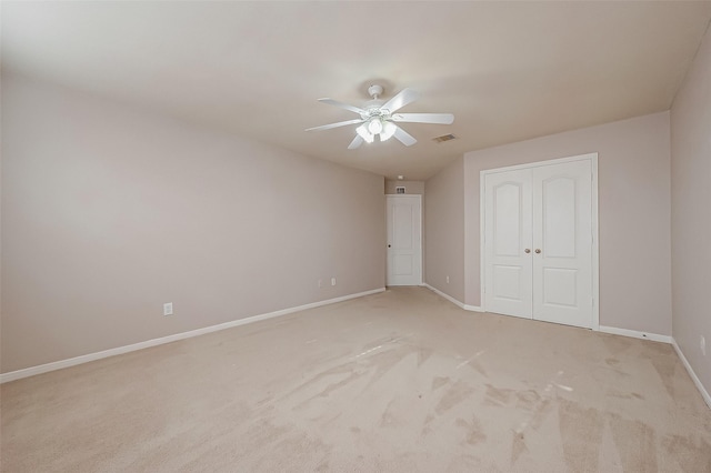 unfurnished bedroom with light carpet, ceiling fan, and a closet