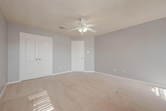 unfurnished bedroom with light carpet, a closet, and ceiling fan