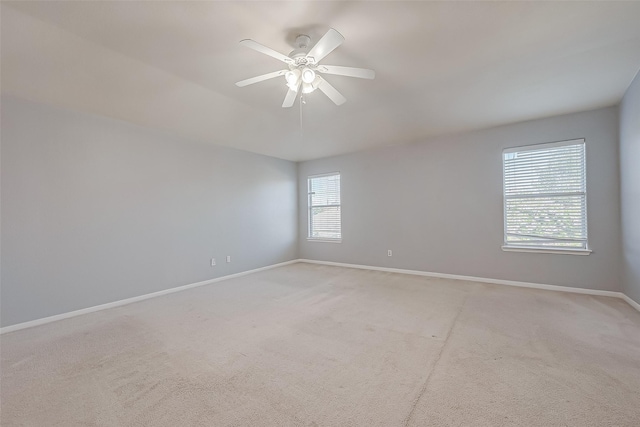 spare room featuring light carpet and ceiling fan