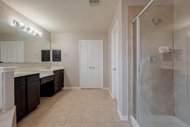 bathroom featuring vanity, tile patterned floors, and a shower with shower door