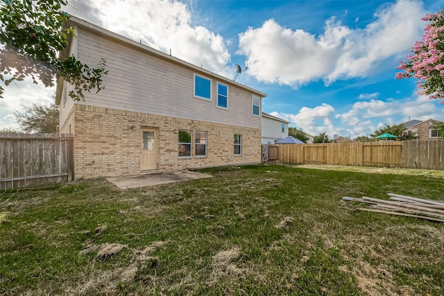 rear view of house with a yard and a patio