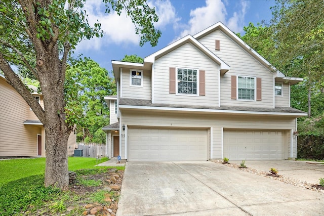 view of front of house featuring a shingled roof, concrete driveway, central AC, a front yard, and an attached garage