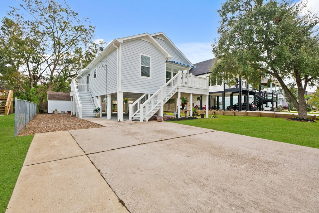 beach home featuring a front lawn and a carport