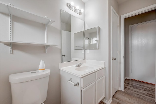 bathroom with hardwood / wood-style flooring, vanity, and toilet