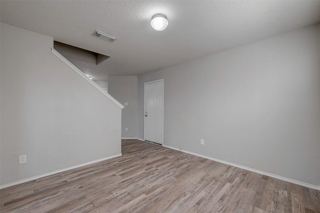 empty room featuring light hardwood / wood-style floors and a textured ceiling