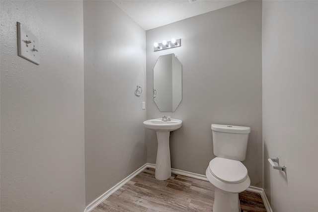 bathroom featuring hardwood / wood-style flooring and toilet