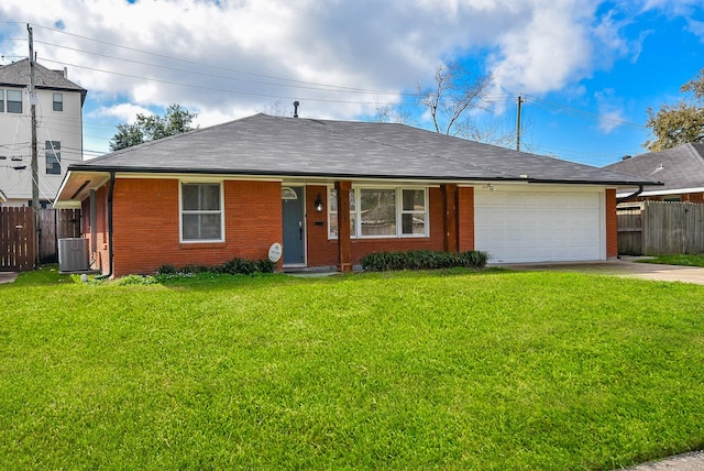 ranch-style home featuring a garage, a front yard, and central AC unit