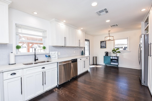 kitchen with appliances with stainless steel finishes, dark hardwood / wood-style floors, sink, and white cabinets