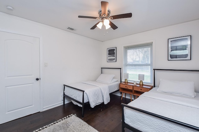 bedroom with dark wood-type flooring, ceiling fan, and ornamental molding