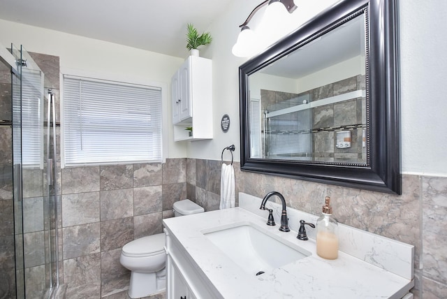 bathroom featuring vanity, a shower with shower door, tile walls, and toilet