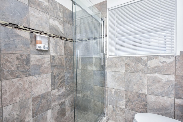 bathroom featuring toilet and an enclosed shower