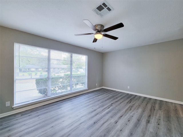 spare room featuring ceiling fan, hardwood / wood-style flooring, and a textured ceiling