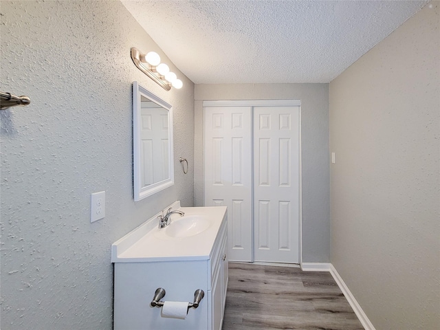 bathroom featuring hardwood / wood-style flooring, vanity, and a textured ceiling