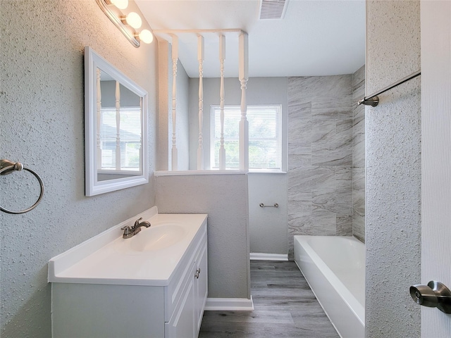 bathroom featuring vanity, a healthy amount of sunlight, and hardwood / wood-style floors