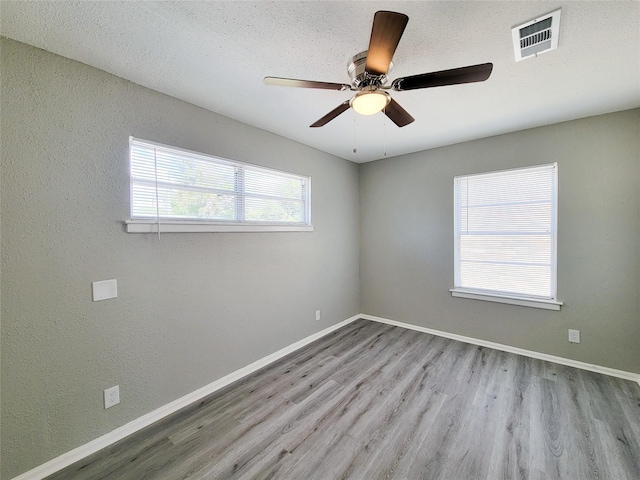 spare room featuring ceiling fan, a textured ceiling, and light hardwood / wood-style floors