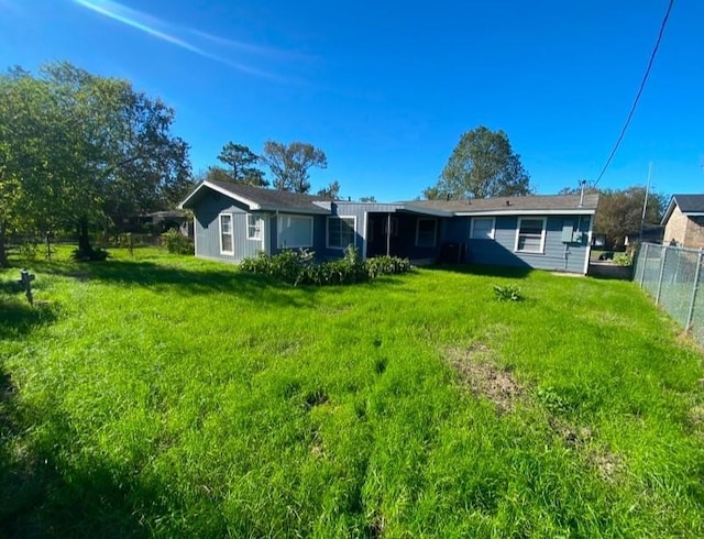 rear view of house featuring a yard