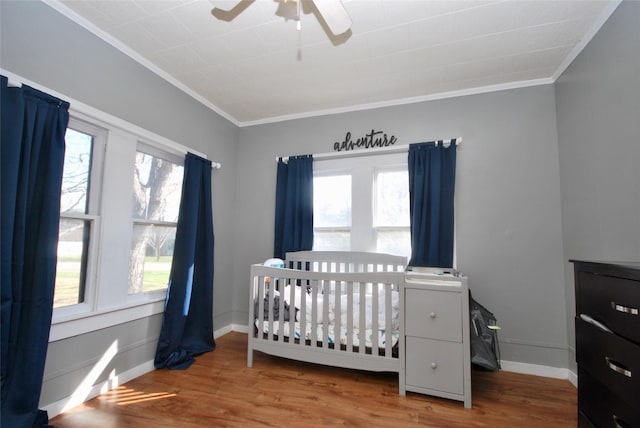 bedroom featuring multiple windows, hardwood / wood-style flooring, and crown molding