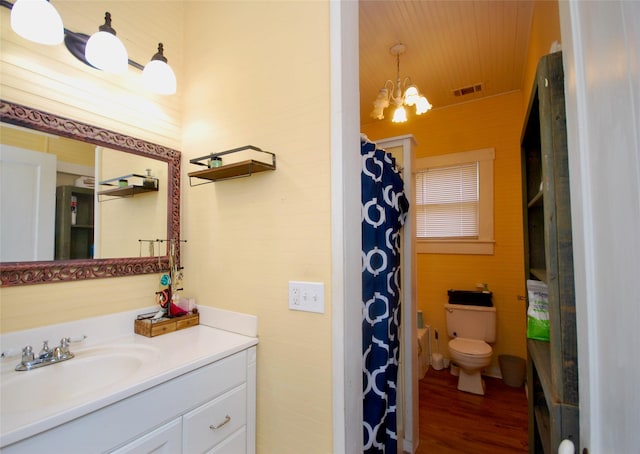 bathroom with toilet, wood-type flooring, a chandelier, vanity, and curtained shower