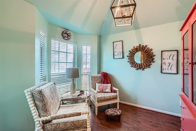 sitting room with an inviting chandelier, dark hardwood / wood-style flooring, and vaulted ceiling